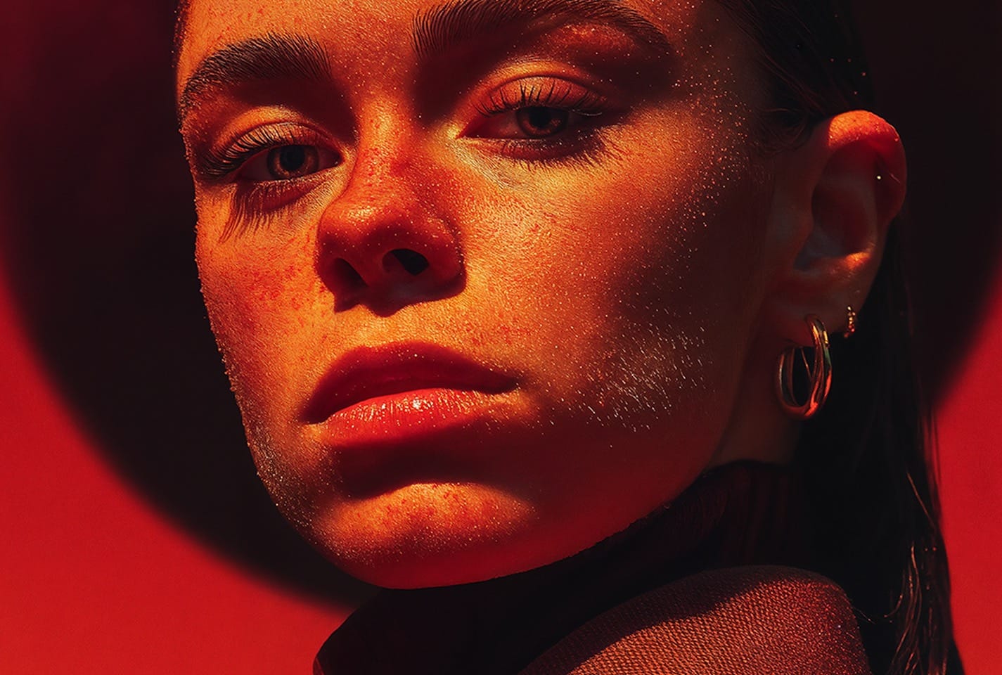 Primer plano de belleza con piel iluminada en rojo y naranja