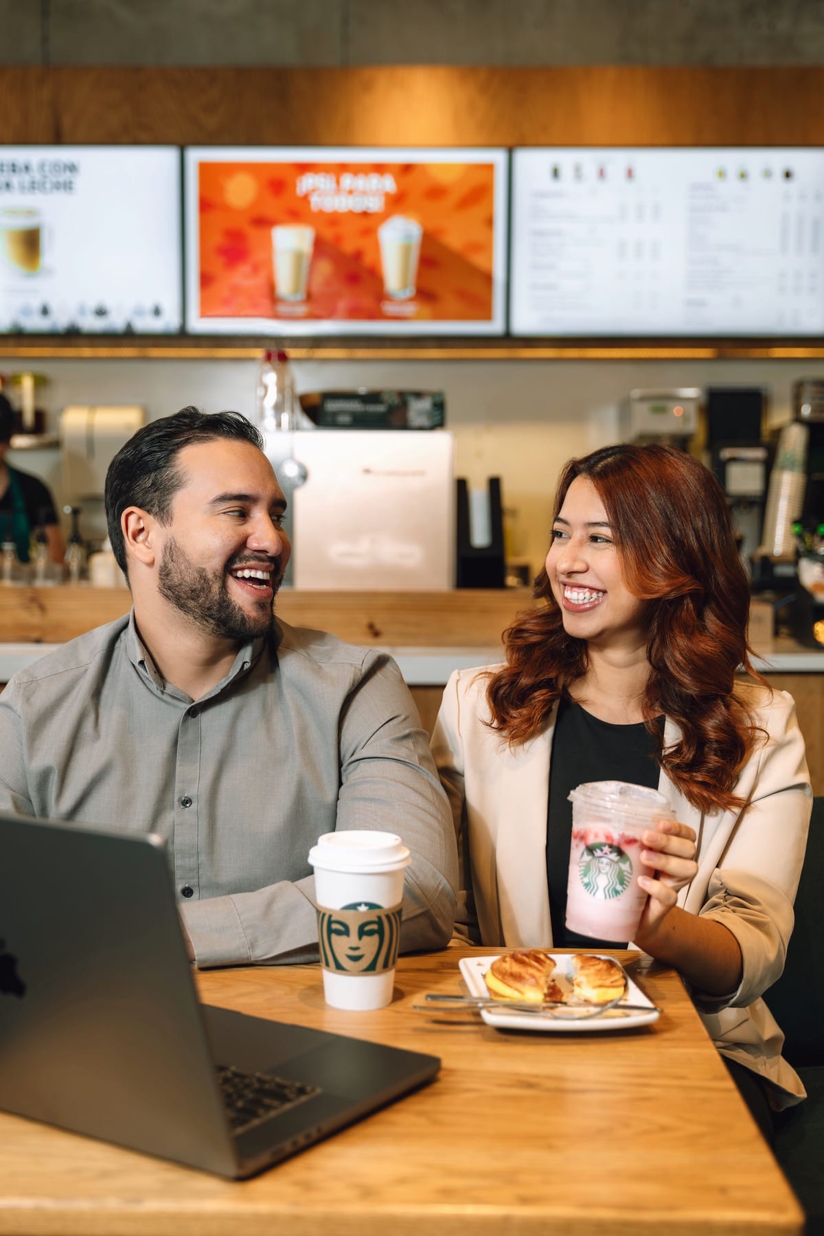Pareja con café y portátil en una cafetería
